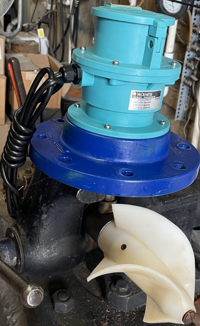A blue and black water pump with a white pipe